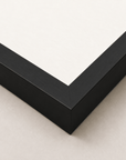 Alimo art print in a black wood frame, corner detail