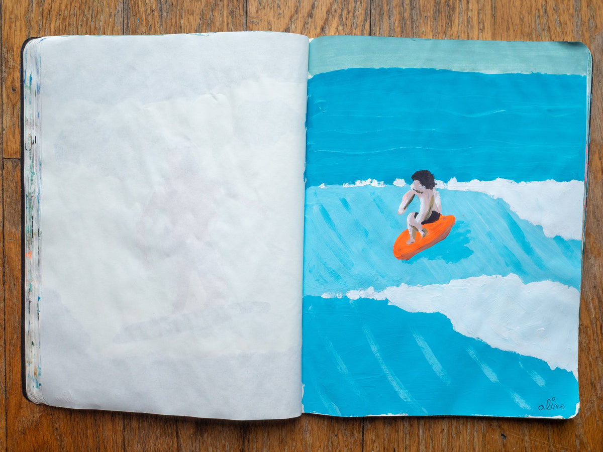 Drop 07 sketch 05 by Alimo in the open Moleskine sketchbook, painted on the right page only: a small surfer on an orange board riding a blue wave
